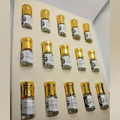 Row of small glass vials with gold caps on a beige background. Attar combo set